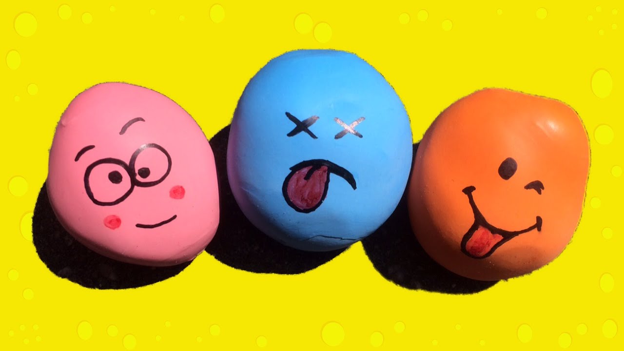 Een roze, blauwe en oranje stressbal met een gezicht gemaakt van ballonnen en zand