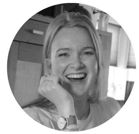 Zwart-wit foto van een vrolijk blond meisje van ongeveer 20 jaar oud. Ze heeft één hand onder haar kin, waardoor haar horloge om haar pols te zien is en uitlegt hoe het leven als au pair eruit ziet
